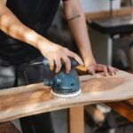 Sander - Craftsman polishing wooden board with grinding instrument