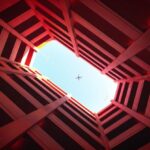 Focal Point - Low-angle Photography of Building Showing Airplane on Skies
