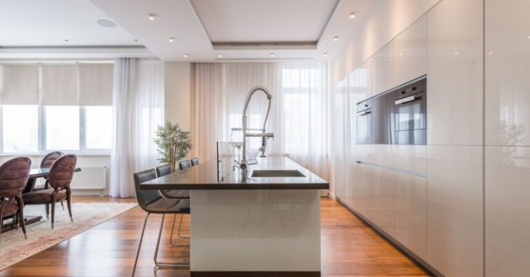 Built-In Furniture - Interior of spacious kitchen with modern minimalist furniture with built in appliances and dining zone in contemporary apartment in daylight