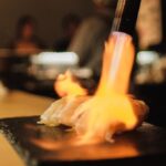 Radiant Heating - A person is cooking a piece of food on a grill