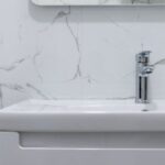 Water Heater - Modern bathroom interior with white washbasin and tap under mirror reflecting water heater at home